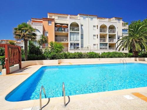 une grande piscine devant un immeuble dans l'établissement T2 au Cap d'Agde avec piscine, parking proche plages - FR-1-749-77, au Cap d'Agde
