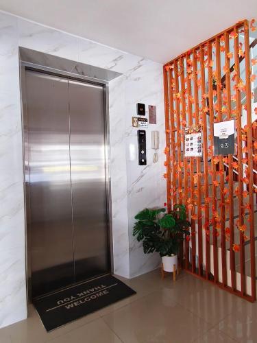 a metal elevator in a lobby with a plant at SNOW HOUSE Buriram in Buriram