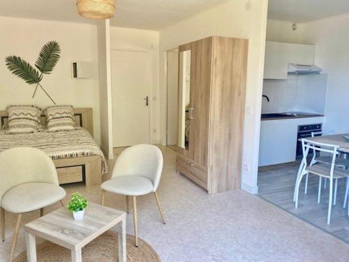 une chambre avec un lit, deux chaises et une table dans l'établissement Studio confortable avec balcon, WIFI, proche cures - FR-1-703-190, à Amélie-les-Bains-Palalda