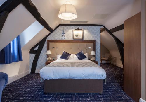 a bedroom with a large bed in a attic at The Crown Wetherspoon in Worcester