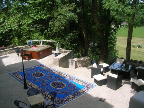 a garden with a tub and a table and chairs at Château Porthos Tranquillité des Pyrénées in Lanne en Barétous