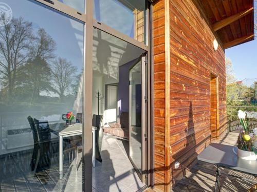 une porte vitrée sur une maison avec un patio dans l'établissement Chalets confortables en bord d'étang, parfaits pour pêche et nature, avec terrasse et équipements modernes - FR-1-496-83, à Veauchette