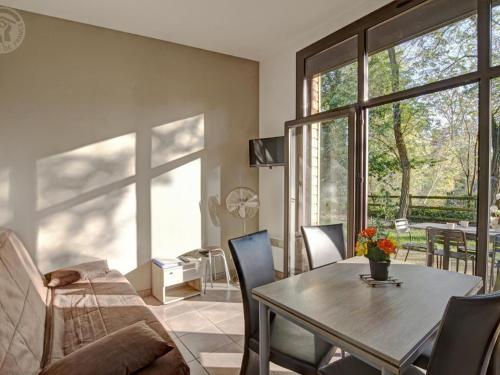 un salon avec une table et un canapé dans l'établissement Chalets confortables au bord d'un étang avec terrasse, jardin et nombreuses activités. - FR-1-496-78, à Veauchette