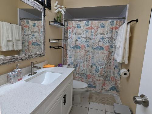 a bathroom with a sink and a shower curtain at Ocean Front by Cocoa Beach Pier in Cocoa Beach