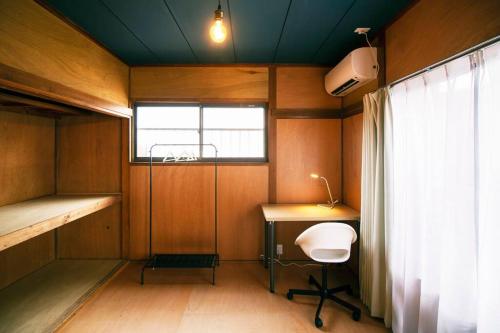 石卷市Roopt 羽黒町的客房设有书桌、床和窗户。
