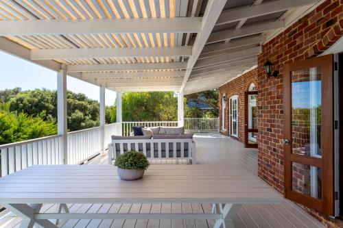 a wooden deck with a table and a couch at Three Bears Cottage I Private Properties in Yallingup