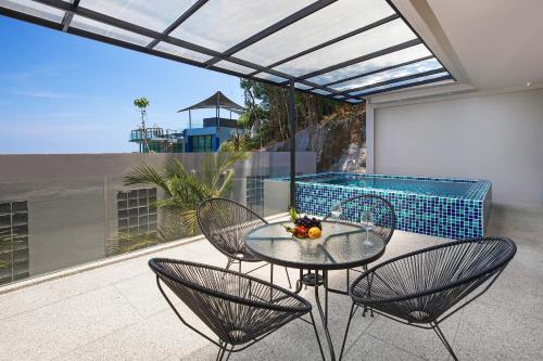 a glass table and two chairs on a patio at Sea View & Tropical Bliss - 2BR Villa Natural Touch A4 at Kamala Hill in Kamala Beach