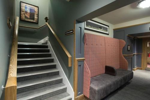 a room with a staircase with a couch and a stair case at Jolly's Hotel Wetherspoon in Dundee