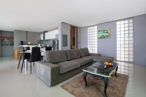 a living room with a couch and a table at Sea View & Tropical Bliss - 2BR Villa Natural Touch A4 at Kamala Hill in Kamala Beach