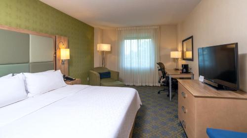 a hotel room with a bed and a flat screen tv at Holiday Inn Express & Suites Cuernavaca by IHG in Cuernavaca