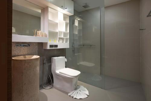 a bathroom with a toilet and a glass shower at Sea View & Tropical Bliss - 2BR Villa Natural Touch A4 at Kamala Hill in Kamala Beach