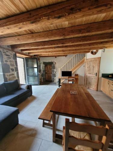 un salon avec une table en bois et un canapé dans l'établissement Maison à la campagne, à Alleuze