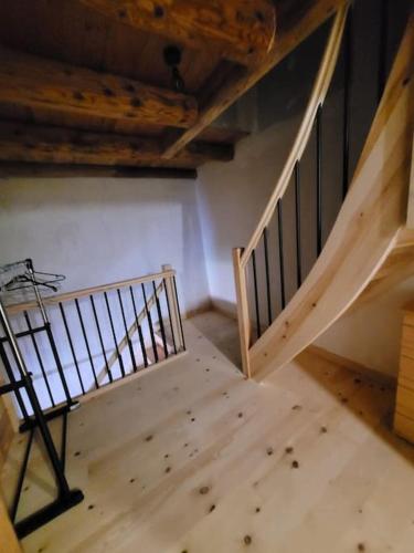 Cette chambre mansardée dispose d'un escalier et de parquet. dans l'établissement Maison à la campagne, à Alleuze