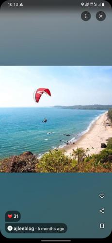 a picture of a person flying a kite over the ocean at Om Ganesh Guest House Cliffside in Arambol
