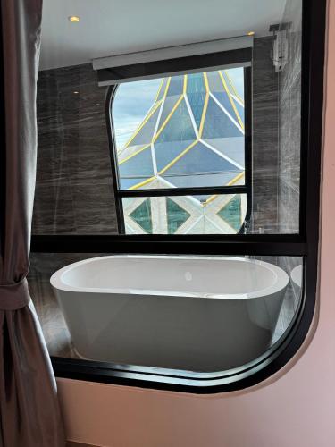 a bath tub in a bathroom with a window at S3 Ayutthaya Hotel in Phra Nakhon Si Ayutthaya