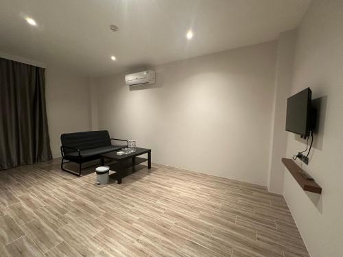 a room with a chair and a table and a tv at S3 Ayutthaya Hotel in Phra Nakhon Si Ayutthaya