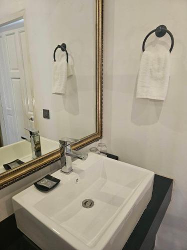 a bathroom with a white sink and a mirror at Lanna Inthan Resort in Doi Saket