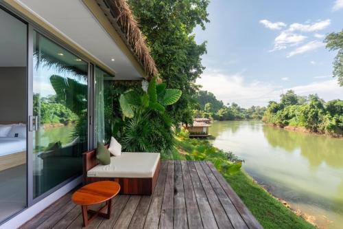 a room with a balcony with a view of a river at Cherlynn Resort in Ban Gaeng Cho