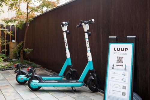 two scooters are parked next to a fence at Hotel Ethnography Kiyomizu Gojo in Kyoto