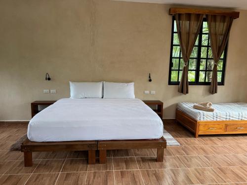 une chambre avec un grand lit blanc et une fenêtre dans l'établissement Casa Jardin del Amor, à Tulum