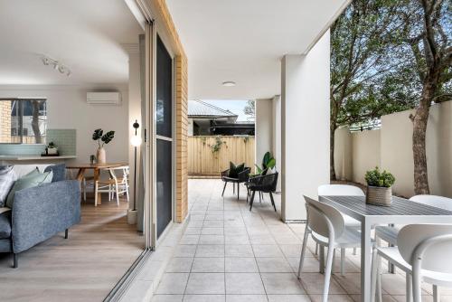 a living room and dining room with a table and chairs at Urban Rest Bondi Beach in Sydney