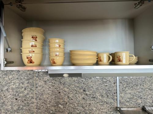 a shelf full of bowls and plates on a shelf at Haeundae Luxury House in Busan