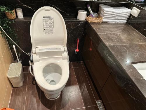 a bathroom with a toilet with the lid up at Haeundae Luxury House in Busan