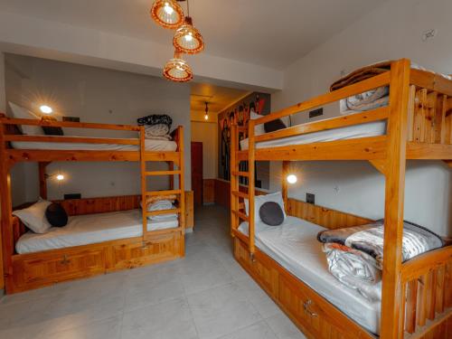 a bedroom with three bunk beds in a room at The Rustic Jibhi - Backpackers Hostel in Jibhi