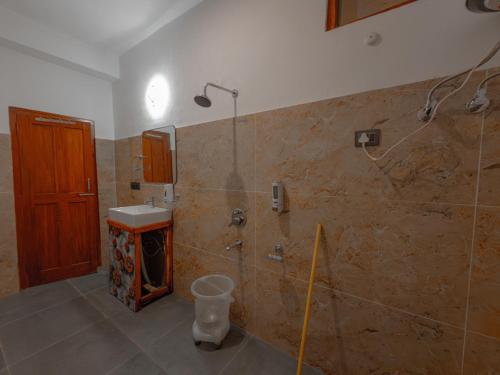 a bathroom with a shower and a sink at The Rustic Jibhi - Backpackers Hostel in Jibhi