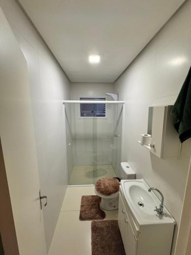 ein Badezimmer mit Dusche, Toilette und Waschbecken in der Unterkunft Casa em imbe in Imbé