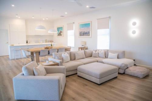 a living room with a couch and chairs and a kitchen at Perranwell House - Aldinga Village in Aldinga