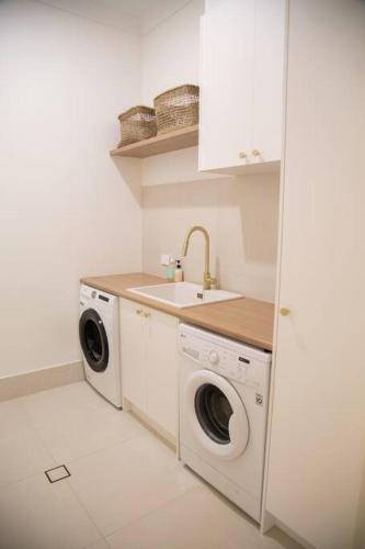a kitchen with a sink and a washing machine at Perranwell House - Aldinga Village in Aldinga