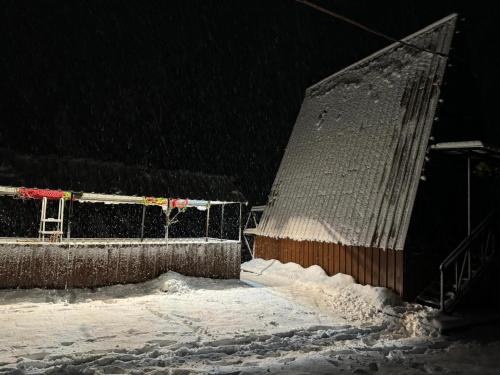 a snow covered building in front of a fence at Paradise Keda in Keda