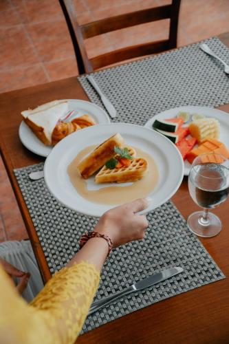a person sitting at a table with a plate of food at Kanaka Villas by Prabha in Tampaksiring