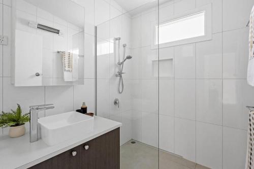 a white bathroom with a sink and a shower at Rye Beach Retreat - newly renovated with private garden and alfresco dining in Rye