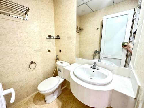 ニャチャンにあるYour Sea Home Nha Trangの白いトイレと洗面台のあるバスルーム