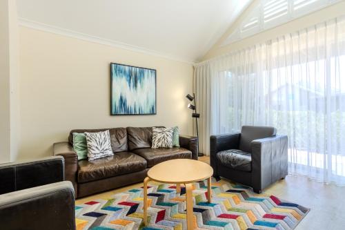a living room with a couch and a table at Albany Bayside by the BnB Collection in Albany