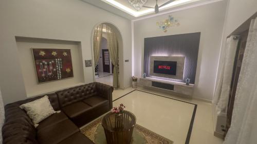 a living room with a couch and a tv at 4bhk Luxury Villa in Mangalore