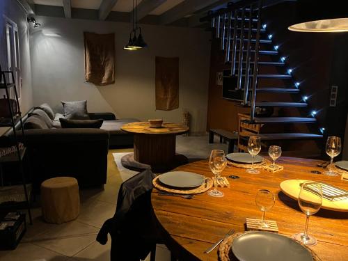 une pièce avec une table avec des verres à vin et un escalier dans l'établissement Le HAUT DES CHANTS, à Sapois