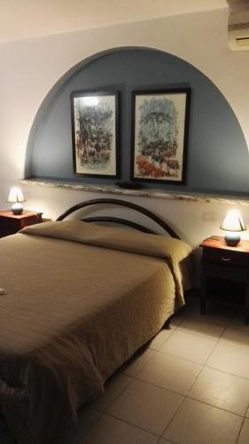 a bedroom with a bed with three pictures on the wall at B&B Villa Acero in Marina di Carrara