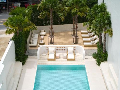 an overhead view of a pool with chairs and palm trees at Arco Phuket Town in Phuket Town