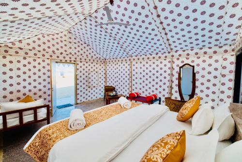 a bedroom with two beds and a mirror at DESERT OVERNIGHT LUXURY CAMP & ReSORT in Jaisalmer