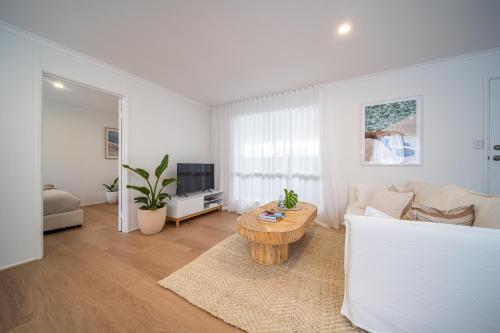 a living room with a couch and a table at ILUKA Luxe accommodation, relaxed coastal vibe in Aldinga Beach