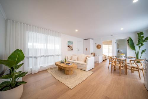 a living room with a couch and a table at ILUKA Luxe accommodation, relaxed coastal vibe in Aldinga Beach