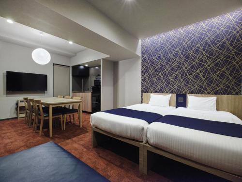 a bedroom with a large bed and a dining room at MONday Apart Premium Nihonbashi in Tokyo