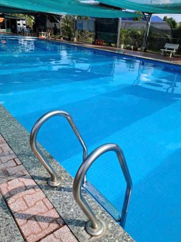 a swimming pool with blue water at Nhà nghỉ Mai Lan in Cái Răng