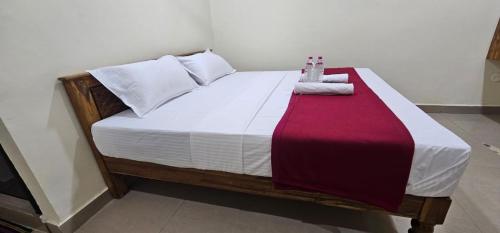 a bed with a red and white blanket on it at Sun Residency Tvm in Tiruvannāmalai