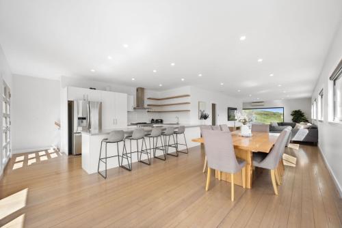 a kitchen and dining room with a wooden table and chairs at Black Diamond - Luxury Alpine Home in Merrijig - Sleeps 14 in Merrijig