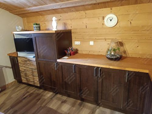 une cuisine avec un comptoir avec une horloge murale dans l'établissement Appartement meublé classé 3 étoiles de 72 m2, 2 chambres, à Morzine