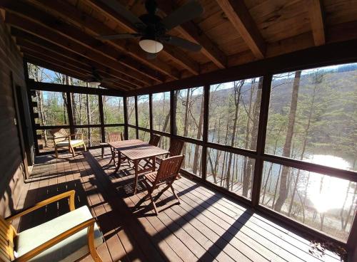 a screened in porch with a table and chairs at JW Hidden Lakes in Ellijay
